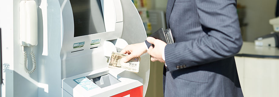 ATMでお金を引き出す男性